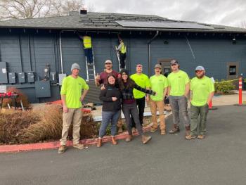 Solar panel installers pose for a photo outside C3 Corvallis Community Center. 