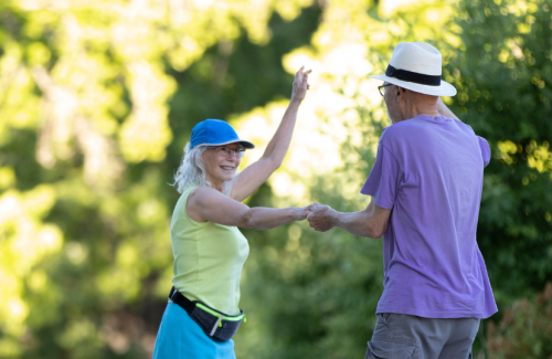 A couple dancing in the middle of Chintimini Park, with the Majestic Theatre and Corvallis Community Center Logos on image.