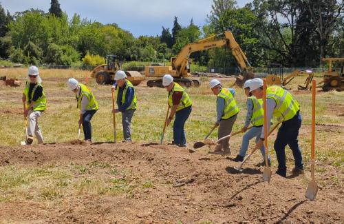 Corvallis City Councilors wearing yellow vests and hard hats at a groundbreaking ceremony for the new Park Maintenance Facility.