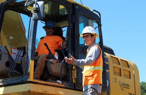 Inspector talking to a worker in an excavator