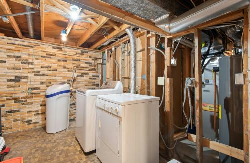 Laundry room remodel showing exposed plumbing and electrical in walls
