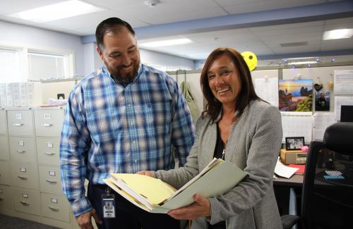 Two Finance staff members reviewing documents in an office