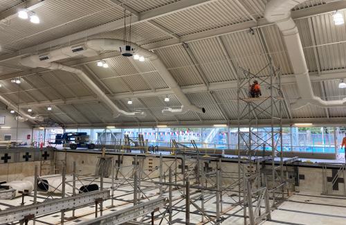 Contractors installing metal shoring supports in the drained pool at Osborn Aquatic Center