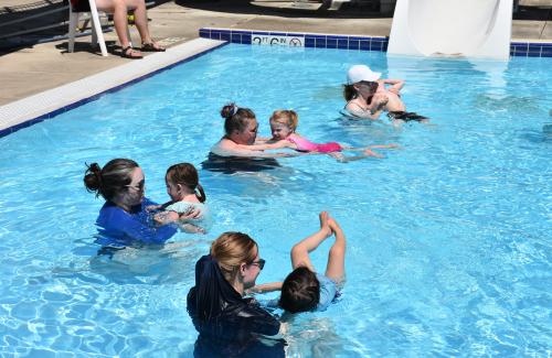 Toddlers and their guardians playing in an outdoor pool
