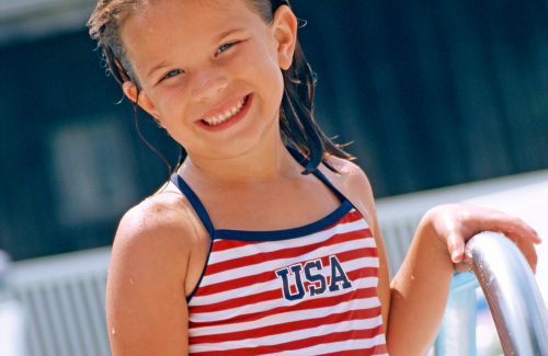 girl in usa flag print swimsuit at swimming pool