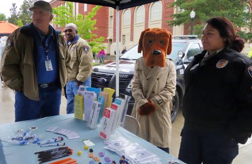 Volunteers and McGruff the crime fighting dog with a table of brochures