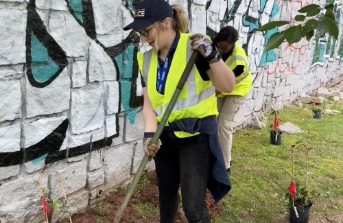 CPD Staff volunteering with park beautification in front of graffiti