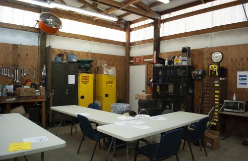 Cramped employee breakroom piled with storage and hazardous materials