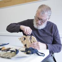 man carving a wooden dragon