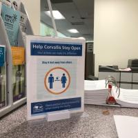 Sign on countertop displaying physical distancing guidelines
