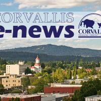 Corvallis e-News Logo on a photo of the city skyline with trees and buildings in the foreground and cloudy blue sky