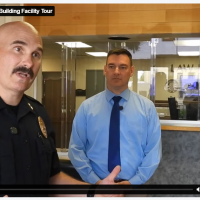 Video screenshot showing uniformed police chief speaking to the camera while standing in a public lobby