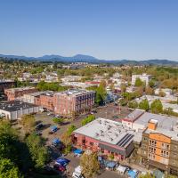 Downtown Corvallis skyline with buildings and trees against a brilliant blue sky.