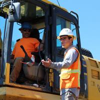 Inspector talking to a worker in an excavator
