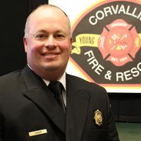 Ben Janes in dress uniform with fire department logo in the background