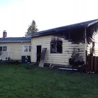 Single family home with burn marks on the garage.