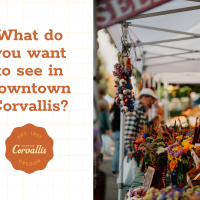 Shoppers browsing a booth at the farmers market, with the words "What do you want to see downtown?" to the left of the photo