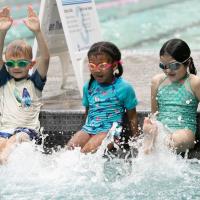 three kids learning to kick water