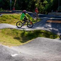 Bike park with paved paths and little kids riding around on bikes.
