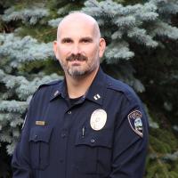 Chief Harvey stands outside in front of a frost covered tree