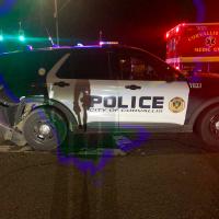 Corvallis Police Department patrol vehicle with moderate-to-severe rear end damage at night
