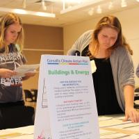 Two people visiting Climate Action Plan tabletop display