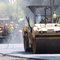 Steam roller laying down asphalt on a city street