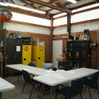 Cramped employee breakroom piled with storage and hazardous materials