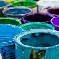 Paint buckets with dried paint in blue, teal, purple colors.
