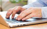 hands typing on a laptop