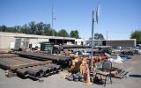 Pipes and equipment being stored outdoors exposed to the elements.