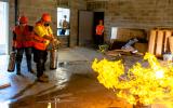 Participants extinguish a trashcan fire.