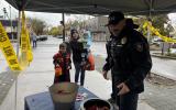 Chief of police hands candy to a trick or treater downtown