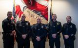 A group of 5 police officers standing at academy graduation
