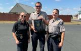 Two cadets and one advisor stand outstide