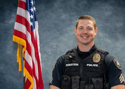 Lieutenant Josh Robertson, in front of a blue background and American flag