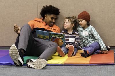 Beavers athlete reading to little kids at the library.