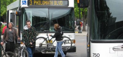 Passenger loading a bike onto the front rack of a CTS city bus.