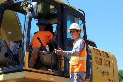 Inspector talking to a worker in an excavator