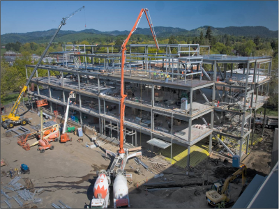 Cranes lifting beams onto metal structure