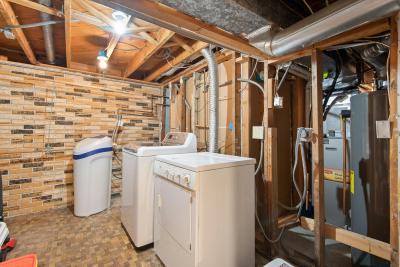 Laundry room remodel showing exposed plumbing and electrical in walls