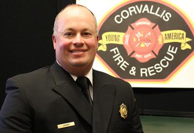 Ben Janes in dress uniform with fire department logo in the background