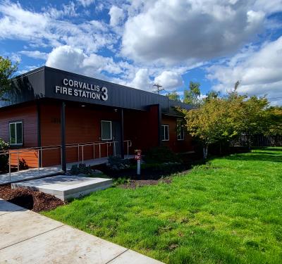 Corvallis Fire Station 3 front door with green grass and a cloudy blue sky.