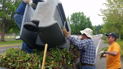 Volunteers emptying landscaping debris into a cart