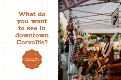 Shoppers browsing a booth at the farmers market, with the words "What do you want to see downtown?" to the left of the photo