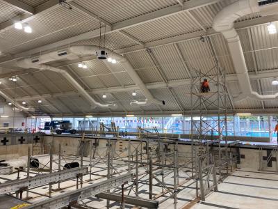 Contractors installing metal shoring supports in the drained pool at Osborn Aquatic Center