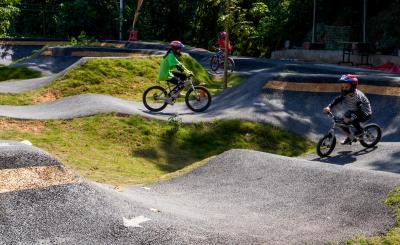 Bike park with paved paths and little kids riding around on bikes.