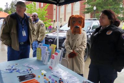 Volunteers and McGruff the crime fighting dog with a table of brochures