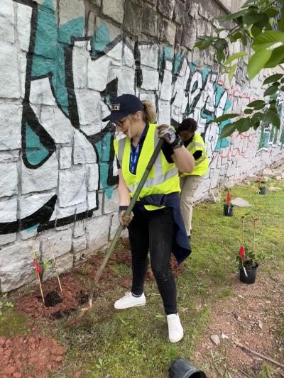 CPD Staff volunteering with park beautification in front of graffiti