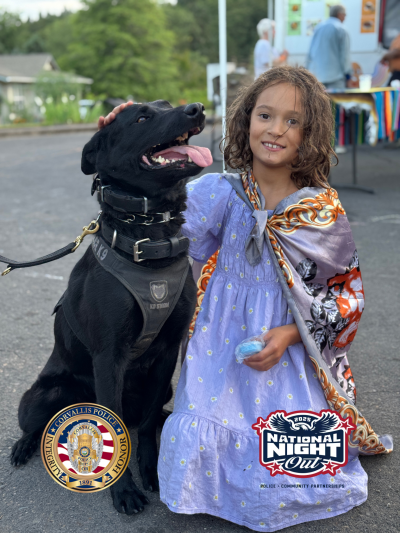 K9 Mazikeen, a black dog, and a young girl in a purple dress at National Night Out